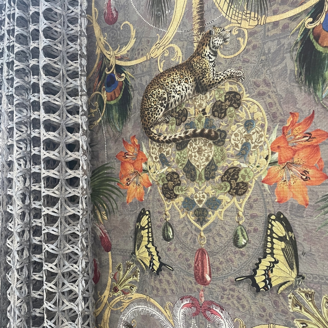 Exotic printed roller blind with a grey cut out curtain layered